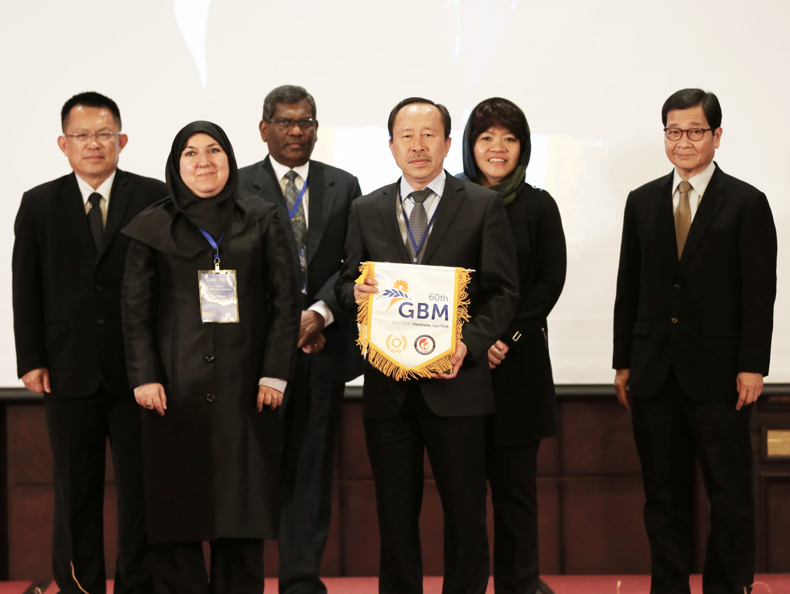 APO Director for IR Iran Dr. Roya Tabatabaei Yazdi (first row L) handing over the GBM flag to 2018 host Lao PDR, represented by APO Director Somdy Inmyxai (R). Looking on were (second row L–R): APO Director for Thailand and Second Vice Chair Dr. Somchai Harnhirun; APO Director for Sri Lanka and First Vice Chair Javigodage Jayadewa Rathnasiri; APO Director for Singapore and Chair Chew Mok Lee; and APO Secretary-General Dr. Santhi Kanoktanaporn.